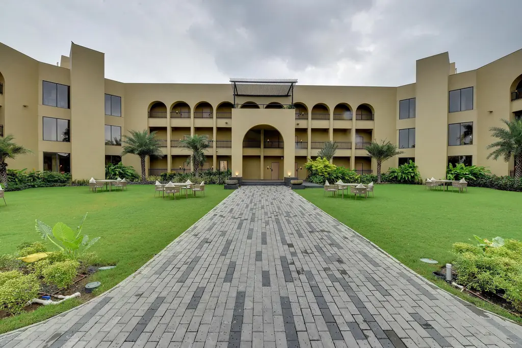 A lawn framed by the resort's arched buildings